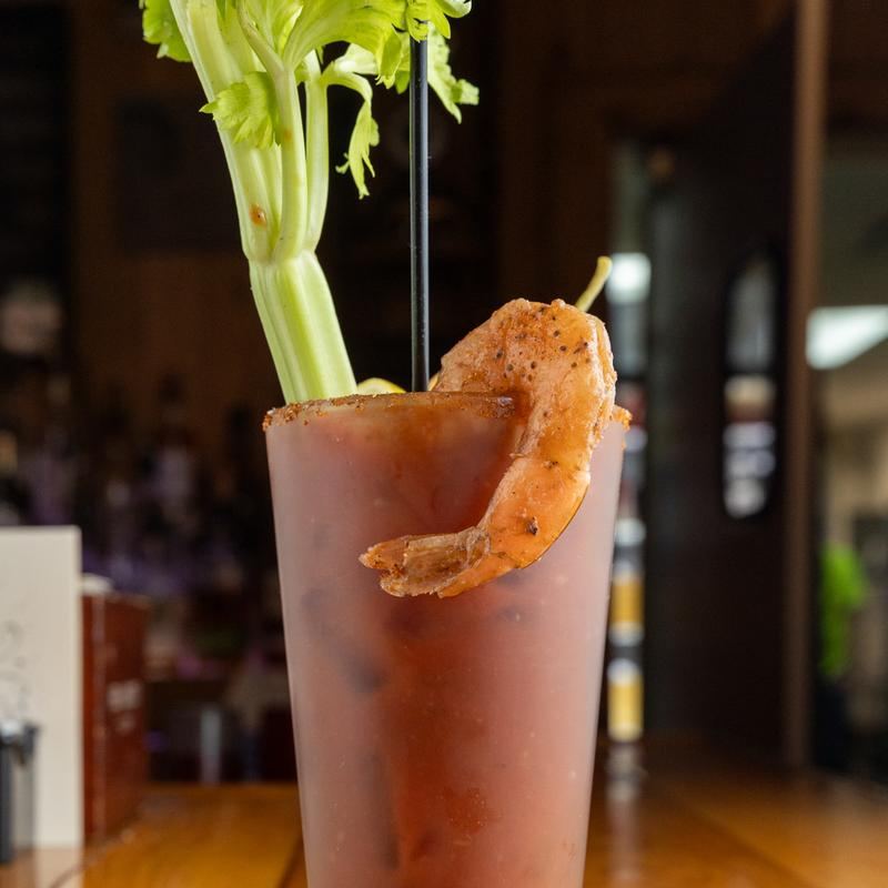 A Bloody Mary garnished with celery and a shrimp